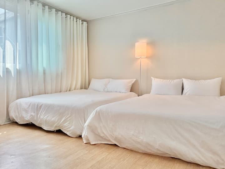 2 queen size-sängar, hotellsängkläder, golvlampor, chiffonggardiner, mörkläggningsgardiner