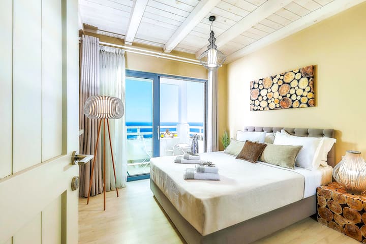Villa 2 - Premier étage - Chambre principale 1 avec lit queen size, salle de bain attenante et balcon privé avec vue sur la mer