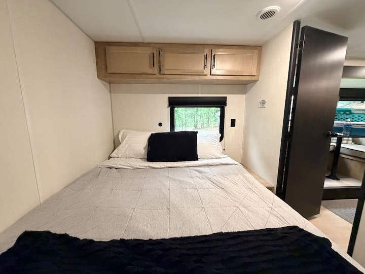 Krevat dopio "queen size" në një dhomë gjumi me derë që mbyllet për privatësi të plotë.
