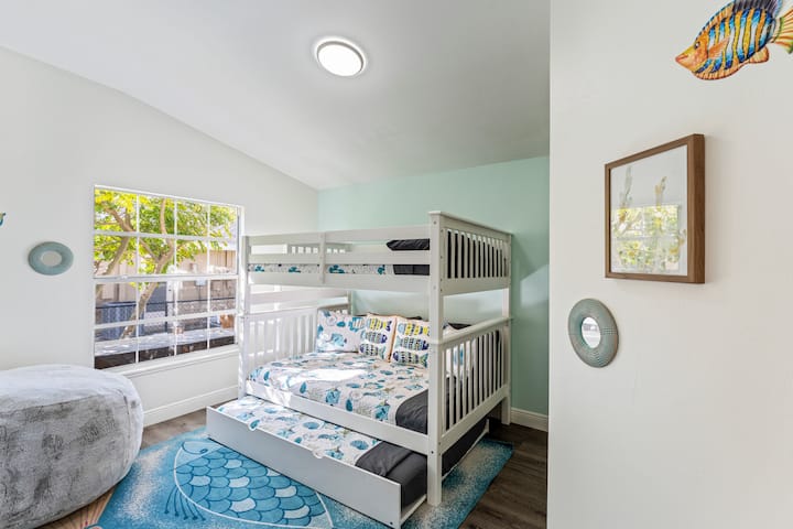 Dormitorio de invitados con una litera triple de tamaño completo y un televisor de 55”. Perfecto para niños, adolescentes o huéspedes adicionales.