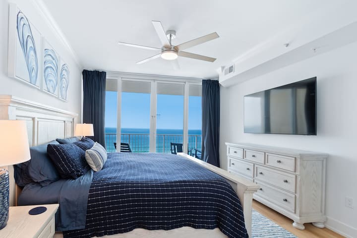 The primary bedroom has direct access to the balcony and a 65-inch TV.