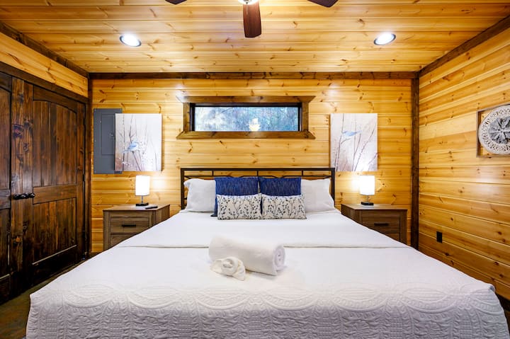 Esta acogedora habitación en una cabaña de madera se siente como un refugio de montaña, con sus cálidas paredes de madera, sus comodidades modernas y esa vista perfecta desde la ventana.