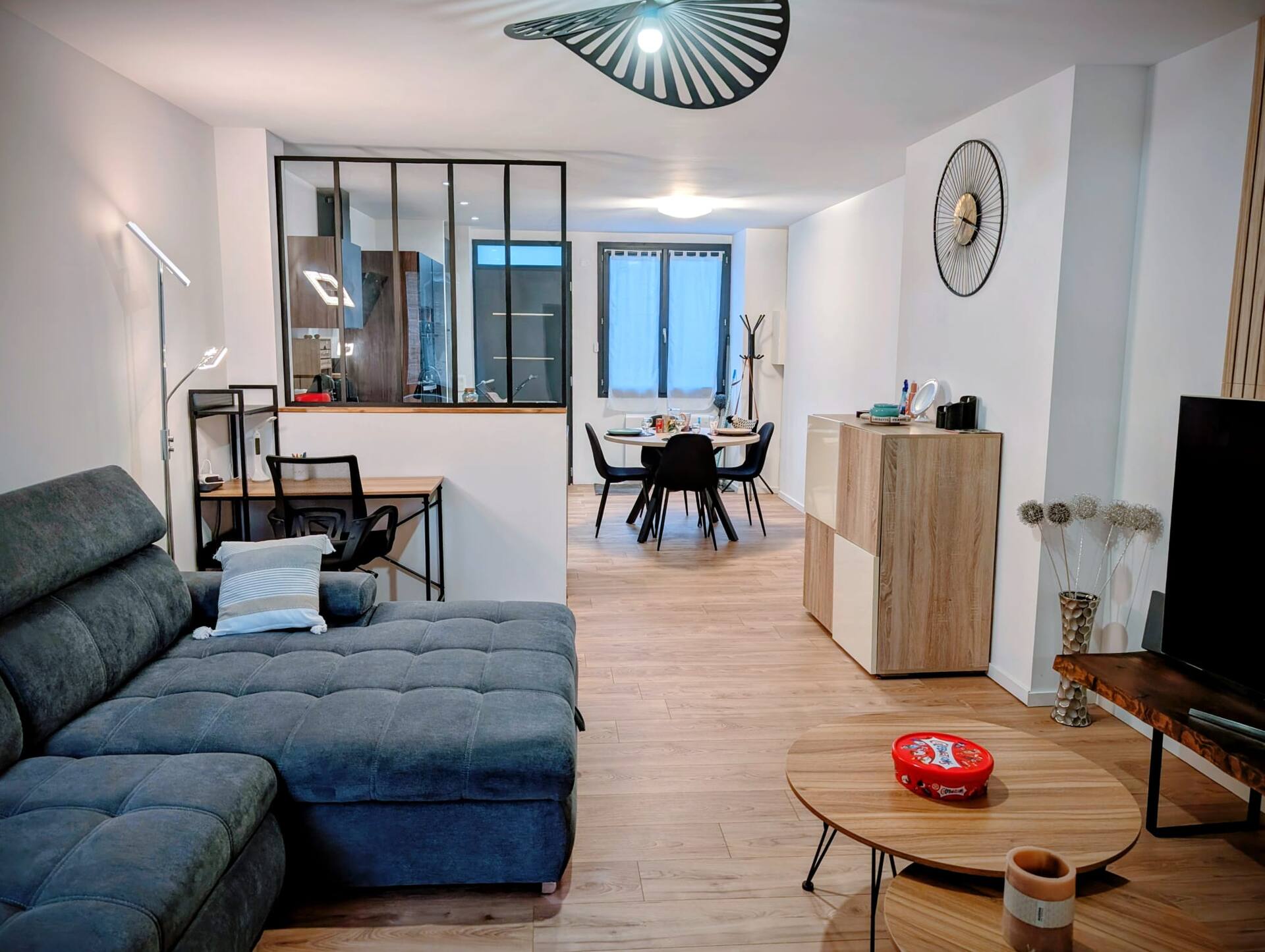 L'Appart — salon avec canapé et TV incurvée