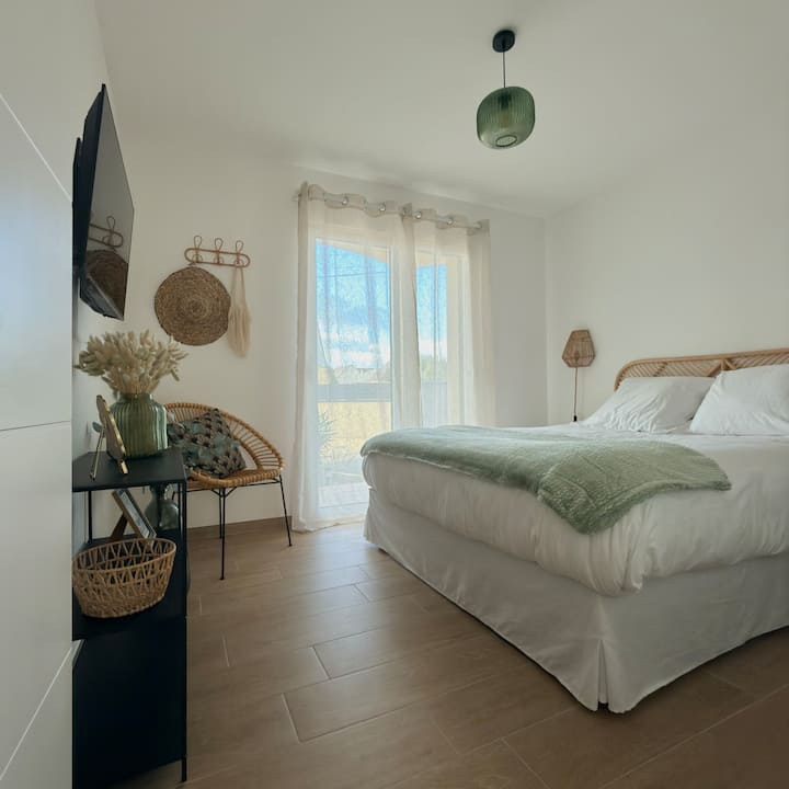 La habitación tiene acceso a una terraza orientada al oeste y está equipada con una cama queen size con colchón y sobrecolchón confort, un televisor inteligente 4K (32”), un ventilador de pie, un armario y una caja fuerte tipo hotel.