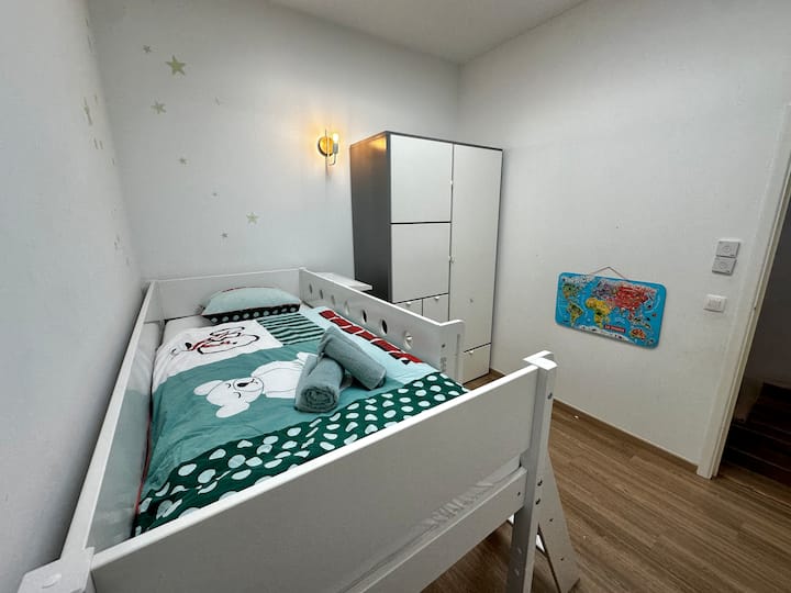 Dječja soba namijenjena obiteljima, s igračkama i prilagođenim prostorom kako bi se mališani odmah osjećali ugodno.