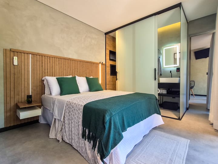Suíte com cama preparada, roupa de cama completa, travesseiros e enxoval selecionado para uma estadia confortável.