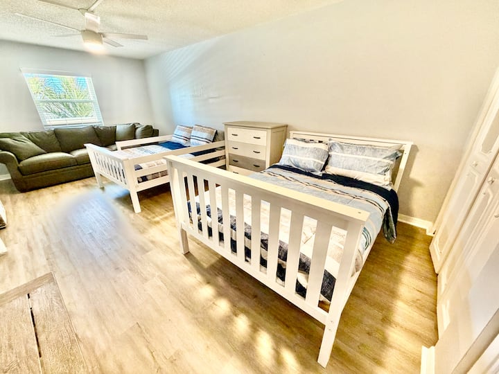 Spacious guest room with two beds and couch — comfortable layout for longer coastal stays