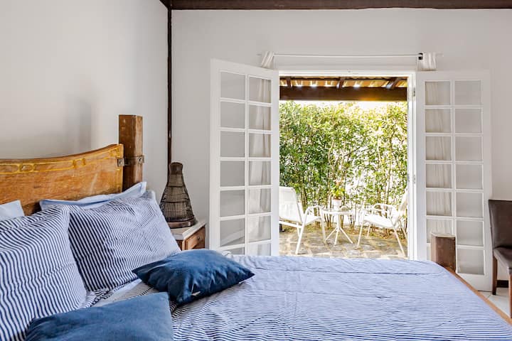 Habitación 1 con baño privado, equipada con cama matrimonial, aire acondicionado, lugar para guardar ropa, ropa de cama y salida directa al balcón.
