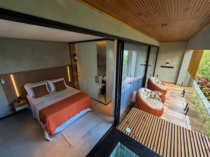 Suíte com cama preparada, roupa de cama completa, travesseiros e enxoval selecionado para uma estadia confortável.