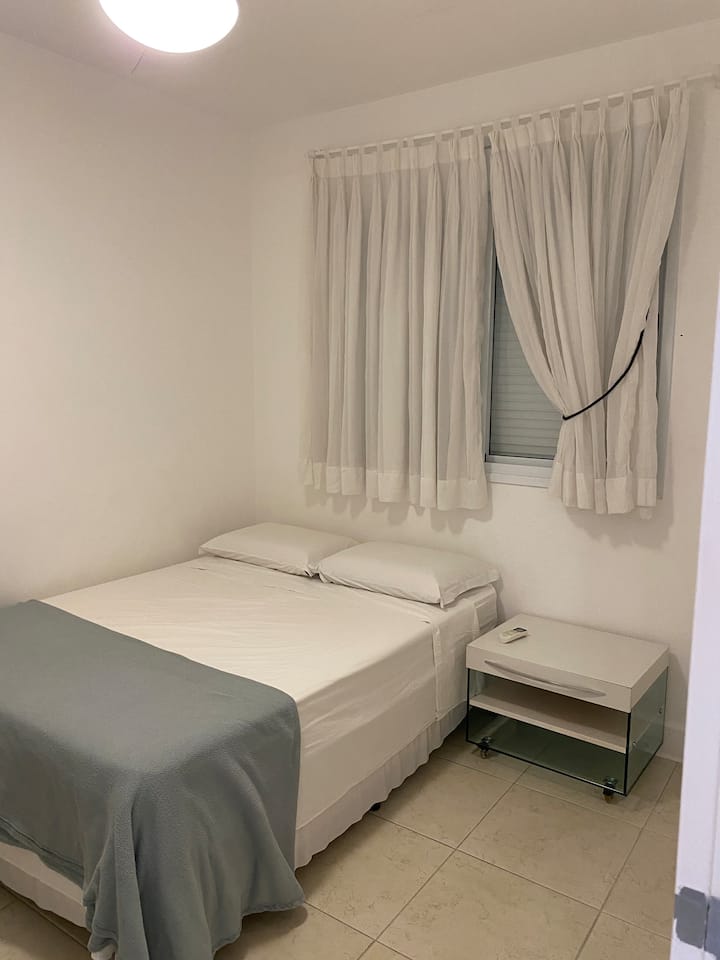 Izba s manželskou posteľou, stlmením, šatníkom, stoličkou, závesmi a tmavým oknom alebo zatemnením  a klimatizáciou