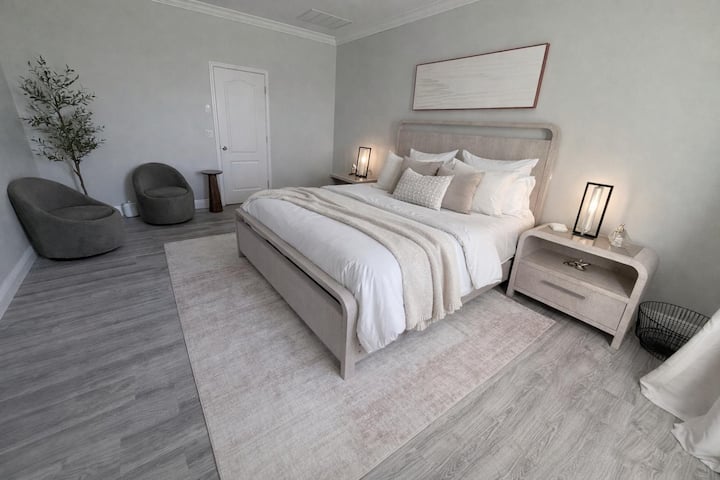 غرفة نوم رئيسية، سرير بحجم كينج مع حمام خاص ومنضدة تزيين.