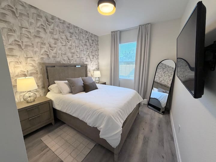 غرفة ثانوية، سرير بحجم كوين، مع تلفزيون، خزانة ملابس وخزانة ملابس مع شماعات ملابس.