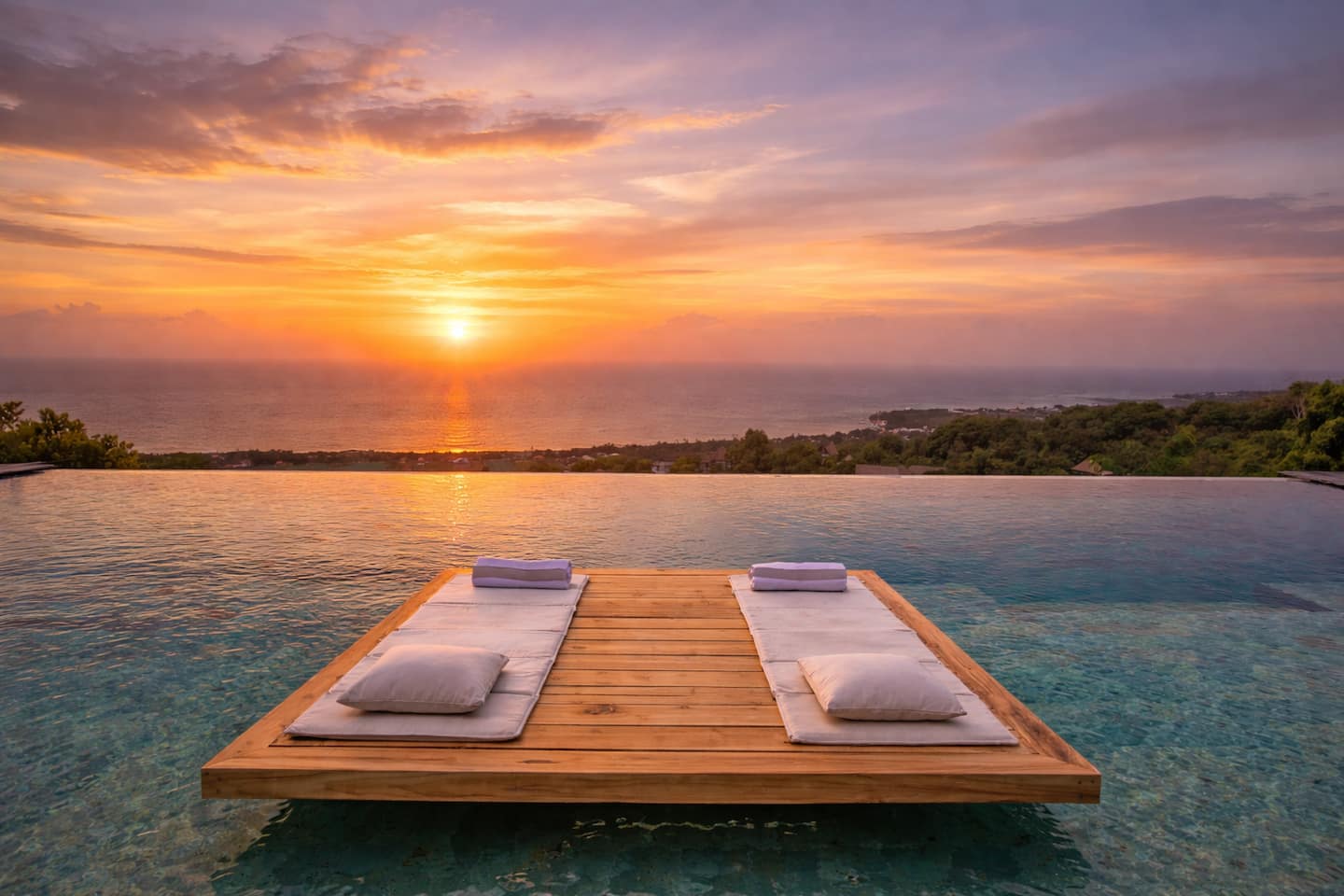 Sunset over the Bali Sea from the floating pool loungers