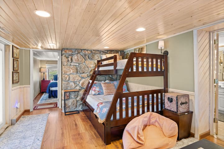 Acogedora habitación con litera en una casa junto al lago, con detalles rústicos de piedra y una distribución ideal para familias; perfecta para estancias en grupo en Lake of the Ozarks.