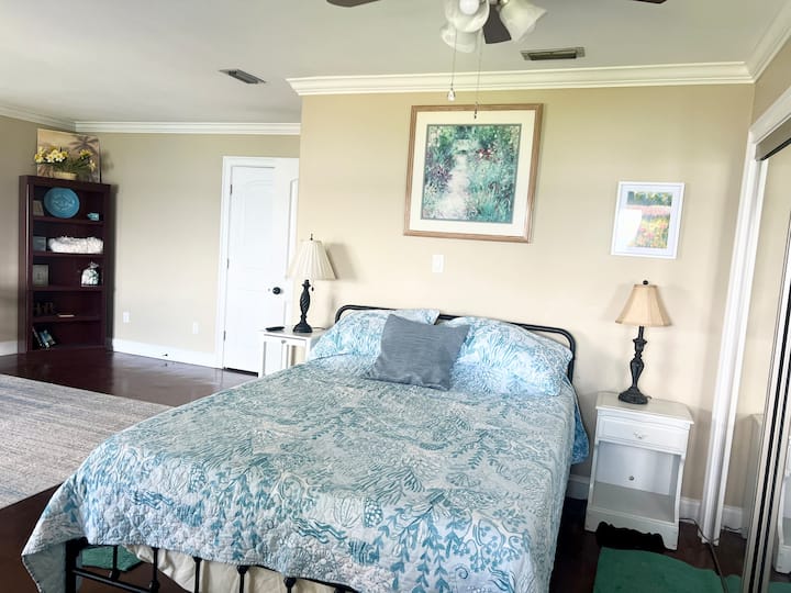 Camera da letto principale sul lago: letto queen-size, TV, scrivania e vista sul lago con accesso al portico coperto