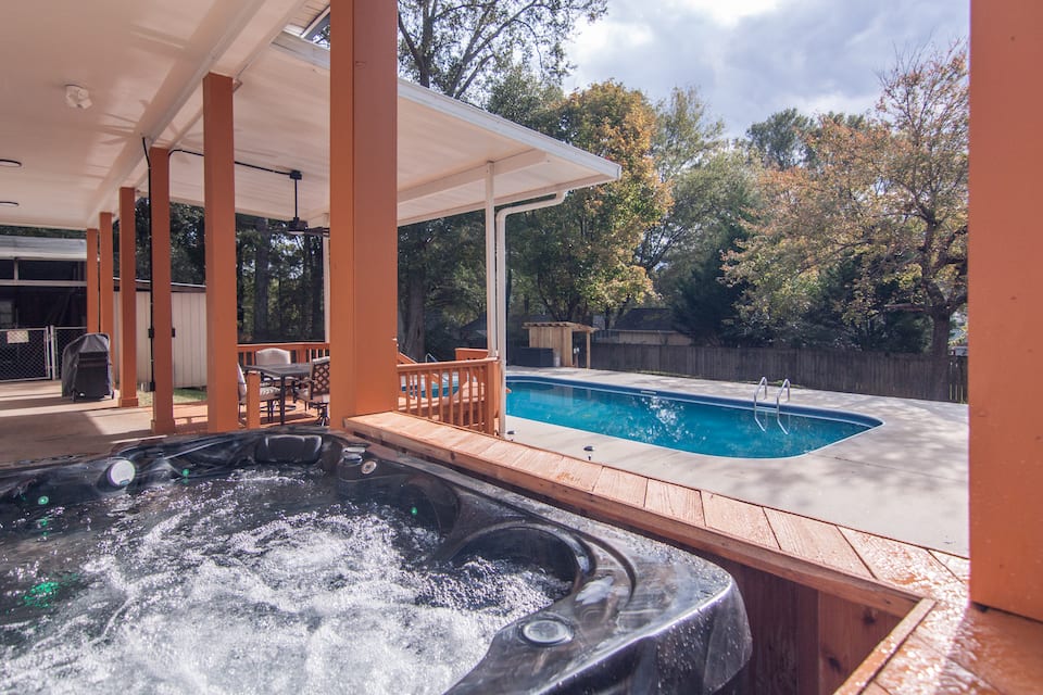 Hot tub under the covered patio with the pool behind