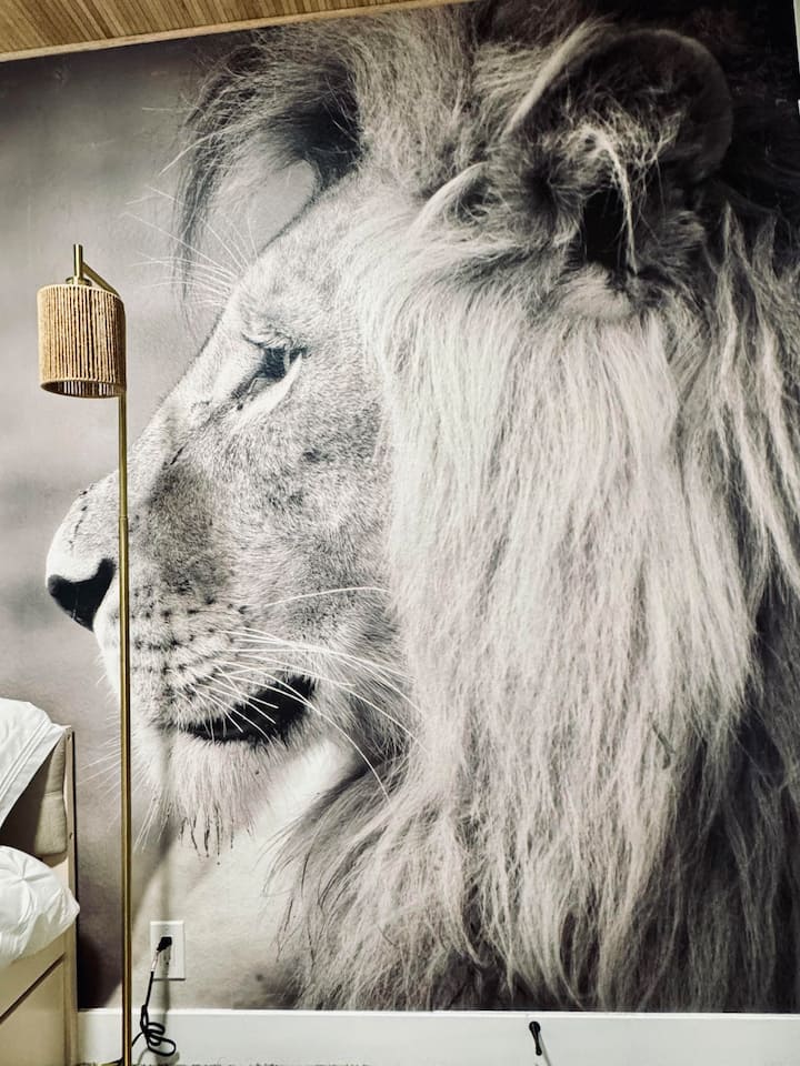 The Portrait of a Predator Bedroom features a dramatic lion mural that brings bold safari energy and unforgettable style to your stay.