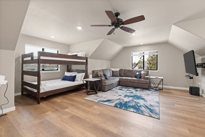 เตียงสองชั้นขนาดใหญ่ โซฟาแบบแยกส่วน และพรมสีสันสดใสทำให้ห้องนี้เหมาะสำหรับเด็ก ๆ หรือการพบปะสังสรรค์เป็นกลุ่ม