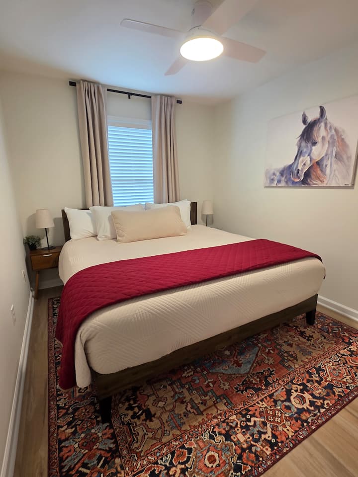Segundo dormitorio recién amueblado y bellamente decorado con cama tamaño king, armario grande y baño privado justo al salir de la puerta.  ¡Un ventilador de techo y cortinas opacas garantizan un sueño reparador y una comodidad total!