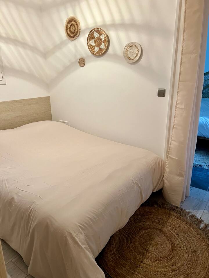 Habitación con una cama de 140 cm, cerrada con una cortina.