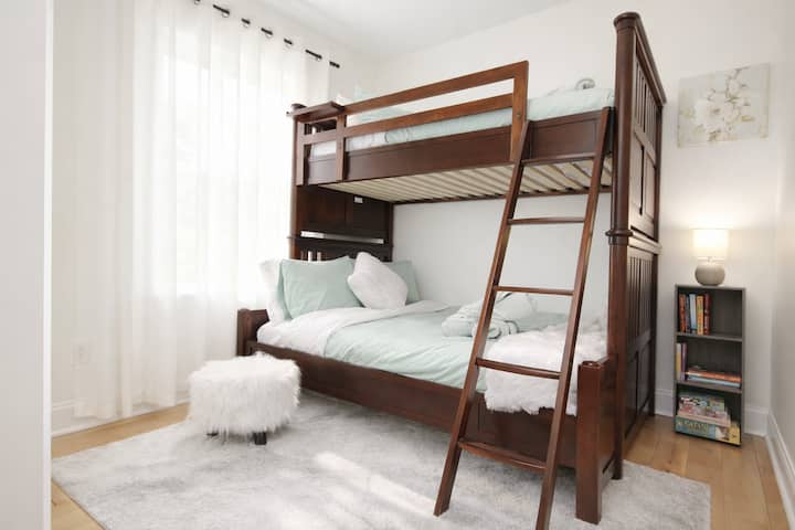 Dormitorio n.º 4: Los tonos cálidos de la madera y las capas suaves crean un espacio acogedor en este versátil dormitorio con litera de dos plazas y una plaza y media.