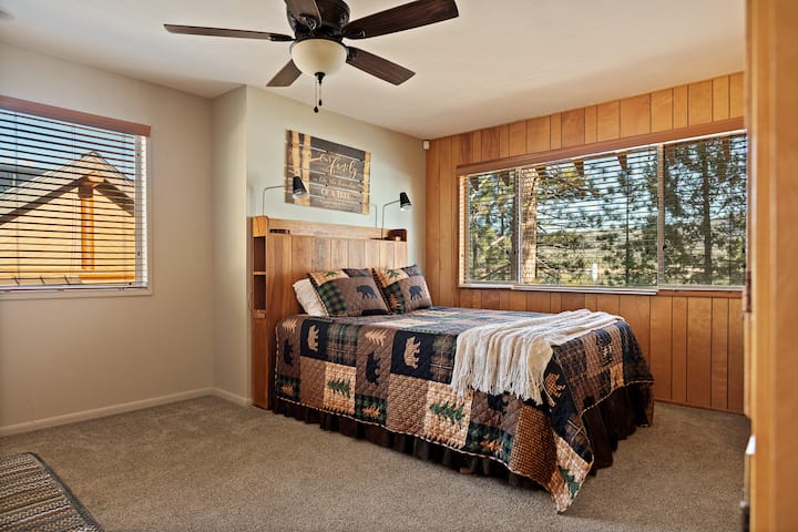 Encantadora habitación para huéspedes con ropa de cama acolchada y vistas apacibles al bosque.