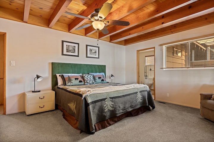 Cómoda habitación con cama king, con vigas de madera cálidas y detalles acogedores de cabaña.