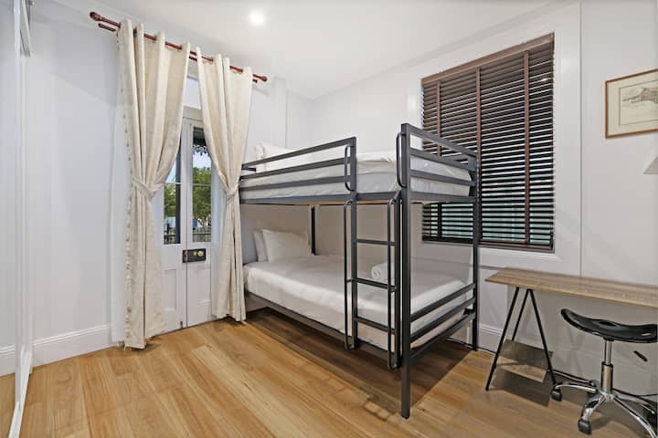 Third bedroom with workspace, natural light and practical bunk layout.