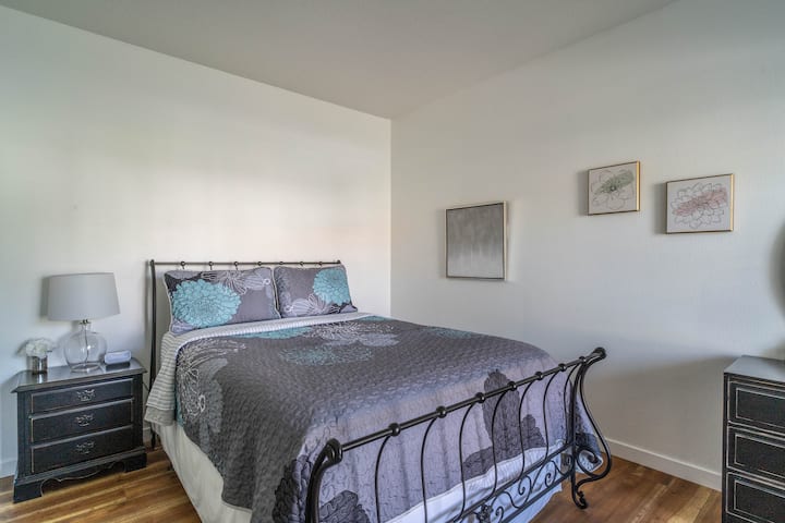 The secondary bedroom includes a queen size bed, plenty of clothing storage, and a nearby bathroom.