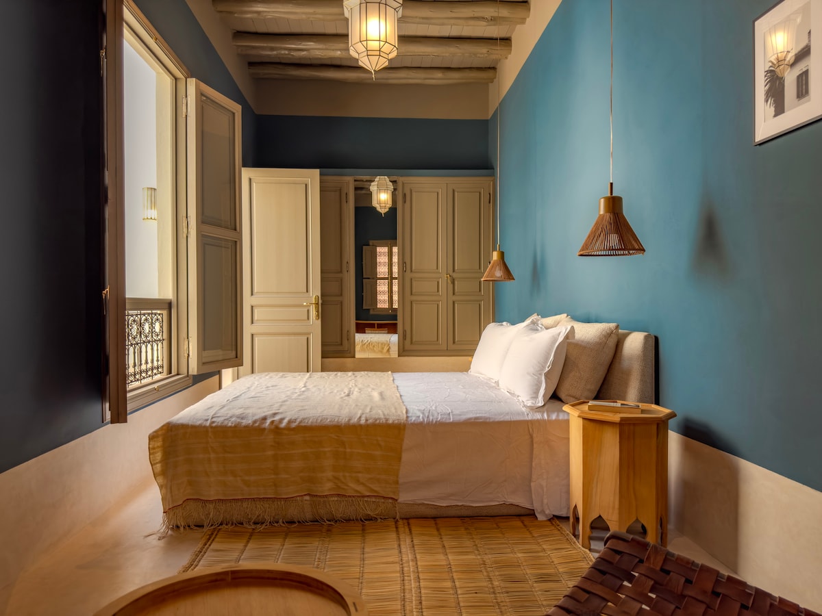 Intérieur d'une chambre du Riad Lalla Chacha, avec son lit king size, ses étoffes luxueuses et son éclairage tamisé, promesse de nuits reposantes à Marrakech.