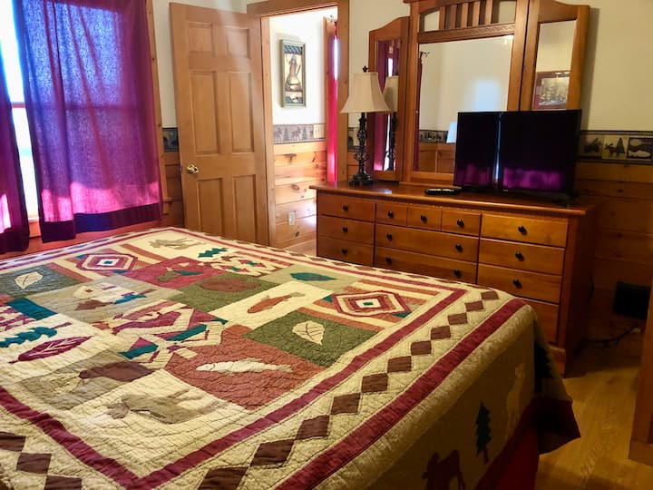 Dormitorio en la planta principal con cama tamaño king y ventilador de techo. Televisión en todas las habitaciones. 