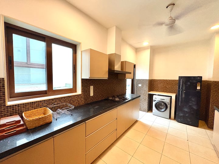 Contemporary kitchen setup with all essential appliances, ample workspace, and an integrated washing