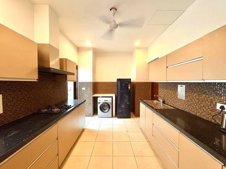 A fully equipped modern kitchen featuring premium appliances and a convenient in-house washing machi