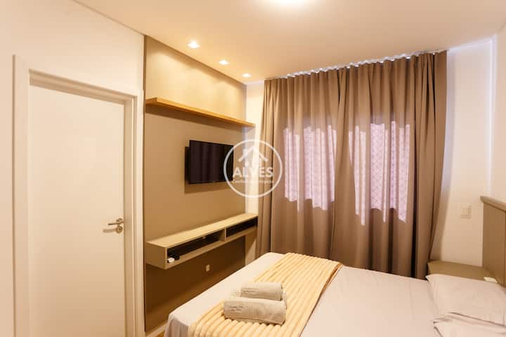 O quarto oferece uma cama de casal aconchegante com suíte e armazenamento closet sob medida. O design clean, com mesas de cabeceira flutuantes e iluminação suave, cria o refúgio perfeito para relaxar após um dia de passeios ou trabalho.