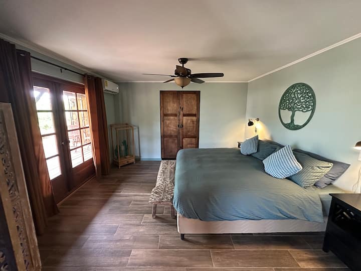 Las puertas tradicionales de madera con persianas crean una cálida bienvenida caribeña al dormitorio principal.