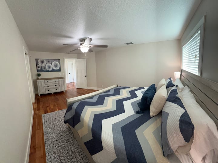 Large master bedroom features a king size bed, two nightstands and a dresser and is attached to the on suite master bathroom.