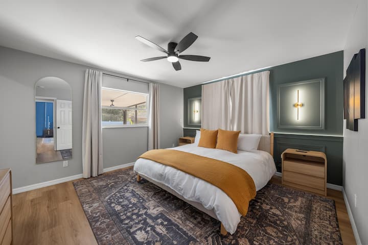 Master bedroom with wall-mounted TV, walk-in closet, and en-suite bathroom.