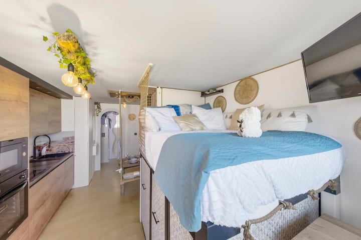 L’esprit du littoral, l’âme du sur-mesure

La pièce de vie révèle tout le génie du sur-mesure : un lit-mezzanine façonné à la main, accessible par un escalier tiroirs qui dissimule un vaste dressing rétroéclairé. 