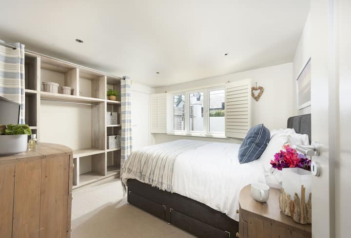 Kingsize bed met eigen badkamer, voldoende opbergruimte, tv en uitzicht op de tuin.