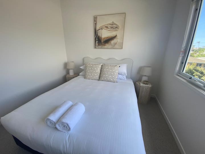 Un dormitorio luminoso con ropa de cama suave y acogedora