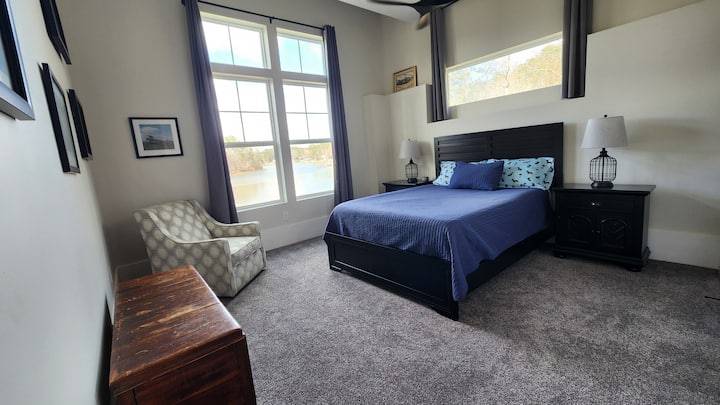 Este refugio en el nivel inferior cuenta con una lujosa cama tamaño queen. Disfruta de tu café matutino en el acogedor sillón de la esquina con vistas al lago. La habitación combina la comodidad moderna con un elegante ventilador de techo e iluminación ambiental LED.