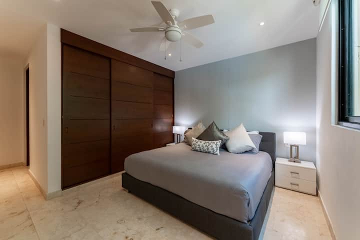Relájate en un dormitorio principal luminoso con cama tamaño king, amplio espacio en el armario, baño privado, televisor inteligente con SKY, cortinas opacas, ventilador de techo y aire acondicionado.