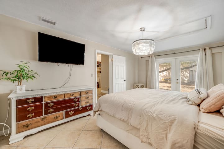 Cama tamaño king con televisor montado en la pared. 