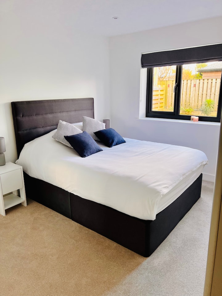 Your second bedroom offers a king sized bed and overlooks the rear garden, again thoughtfully designed with ample storage for you to unpack your things.  A convenient ensuite with shower is modern and a relaxing space to refresh after a day outdoors.