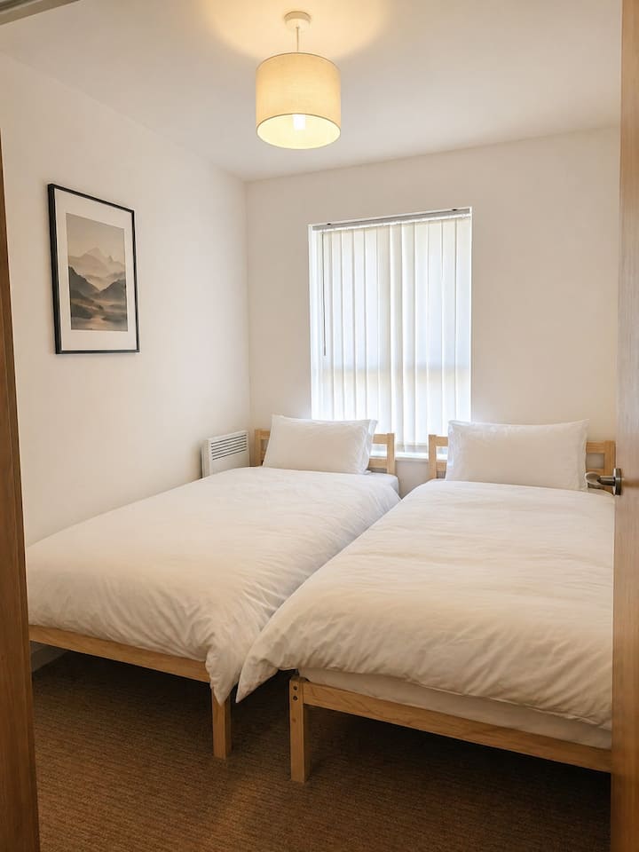 Recámara luminosa y acogedora con dos cómodas camas individuales con sábanas limpias y muebles suaves. Perfecta para amigos, colegas o familiares, esta habitación ofrece un espacio tranquilo y relajante para descansar después de un día explorando la ciudad.
