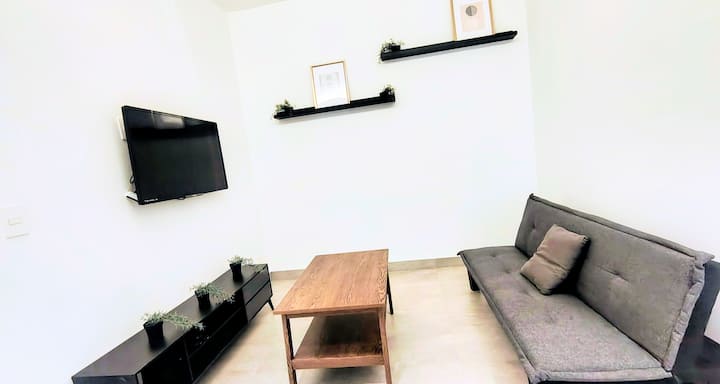 Sala funcional con sofá cama y Smart TV, ideal como espacio adicional para huéspedes en CDMX.