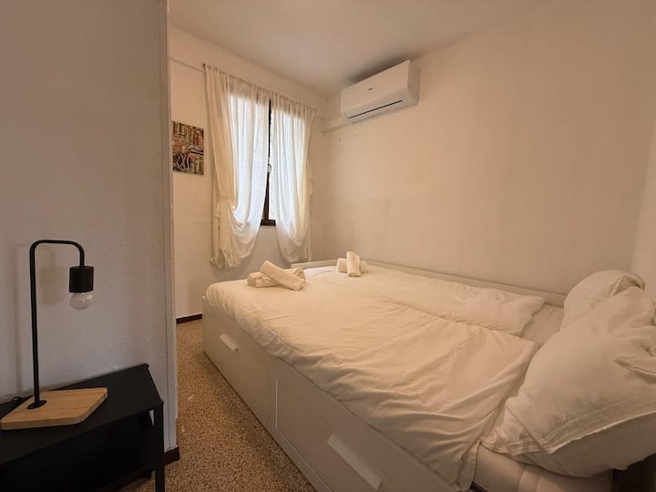 Dormitorio 2 con lámpara de lectura y ambiente tranquilo.