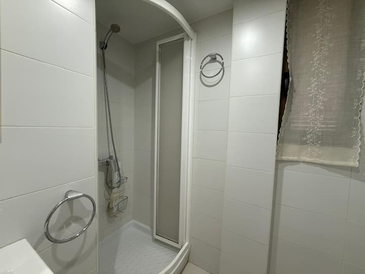Ducha con mampara y cortina: funcional y limpia.