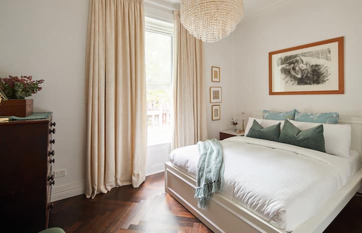 استرخ في غرفة النوم الرئيسية التي تتميز بسرير كوين مع بياضات ناعمة وستائر تعتيم للمساعدة في خلق ليلة هادئة ومريحة.