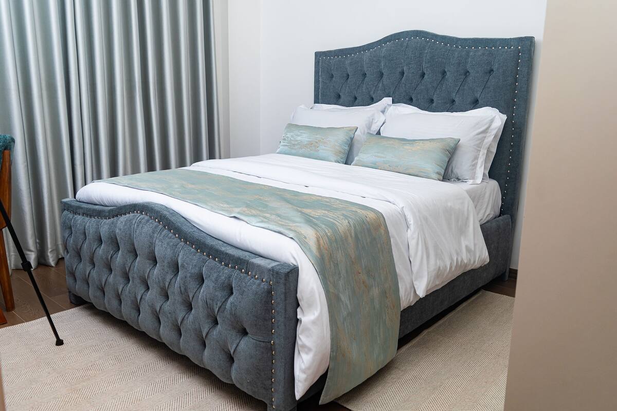 King bed with tufted headboard and curtains